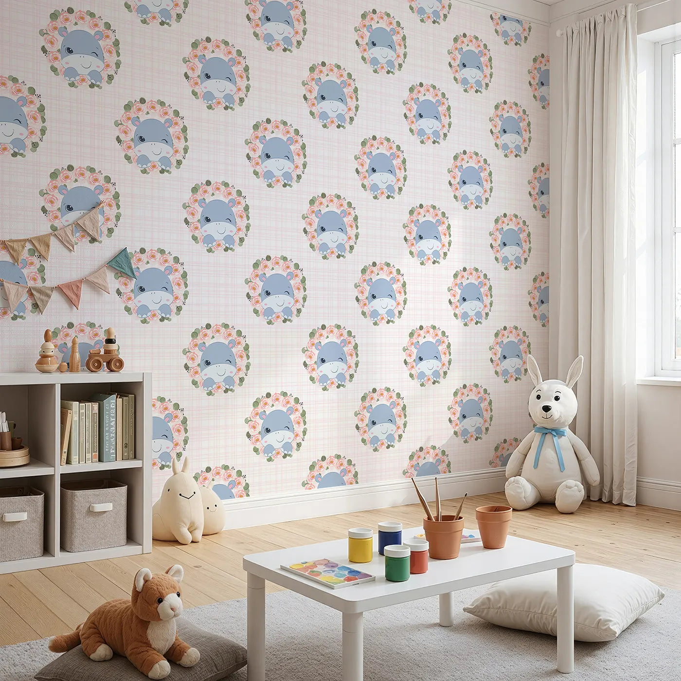 Angled view of Whimsy Tots' Blossom Hippo Winks Wallpaper in Pink Garden (W3103A).A sweet blue hippo peeks through rose wreaths with a wink and a giggle.