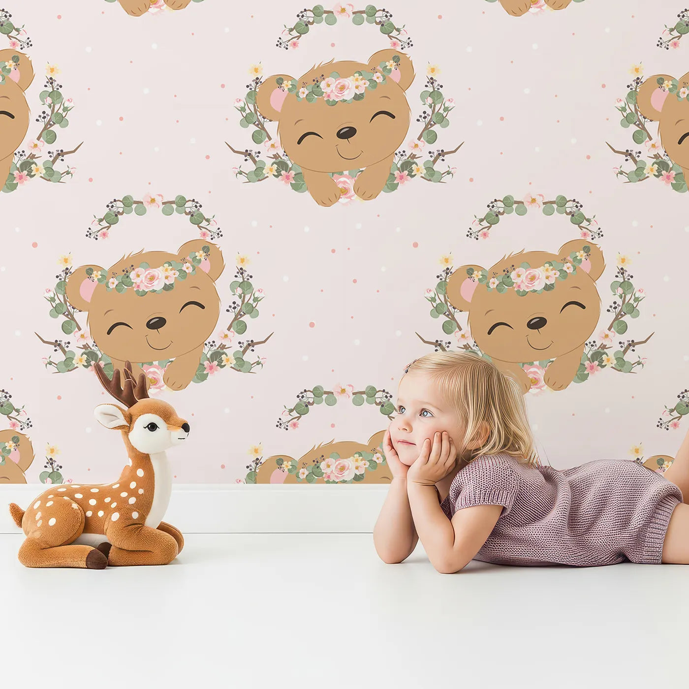 Lovely child standing in front of Whimsy Tots Floral Bear Hugs Wallpaper in Blush Pink with bear, flower, crown, branch, leaf in design.