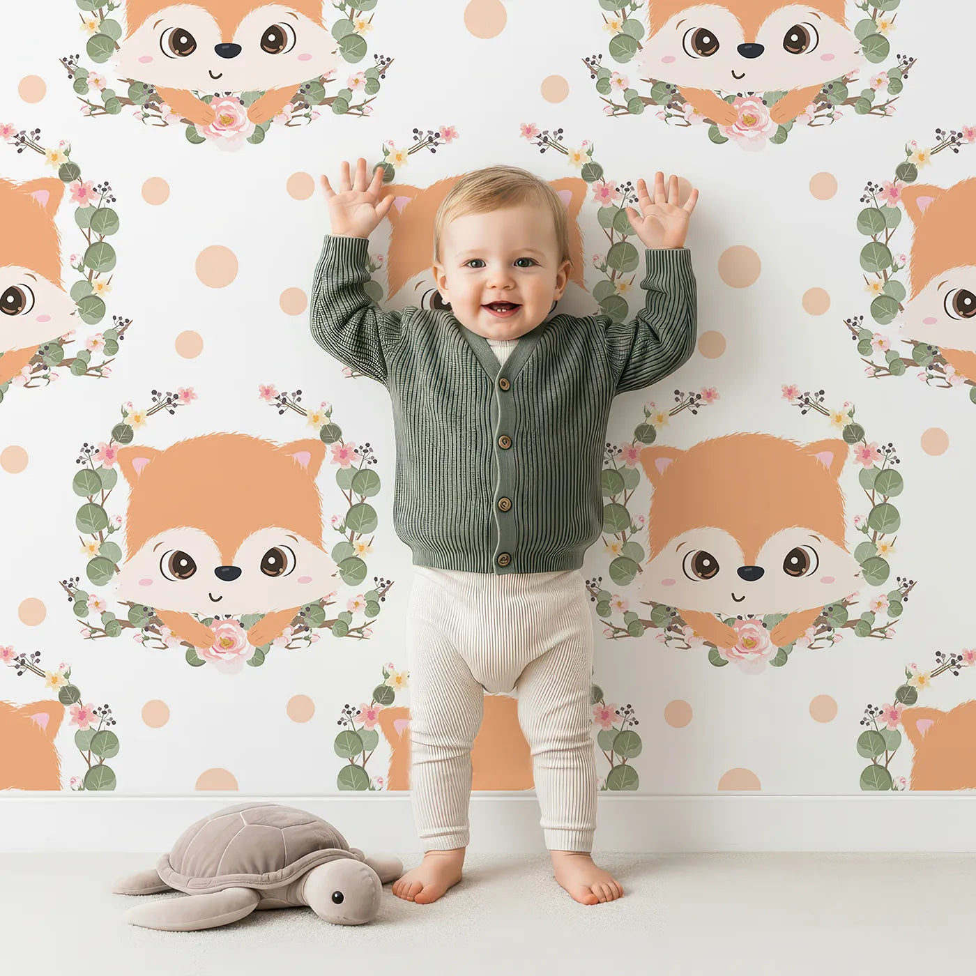 Lovely child standing in front of Whimsy Tots Floral Fox Peek Wallpaper in Soft Peach with fox, flower, crown, branch, leaf, polka in design.