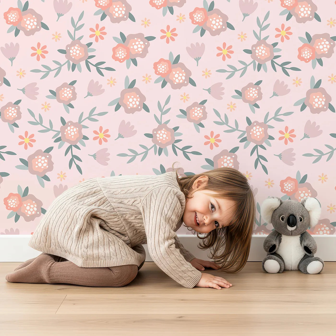 Lovely child standing in front of Whimsy Tots Whispering Peony Garden Wallpaper in Blush Kiss Pink with flower, peony, daisy, leaf in design.
