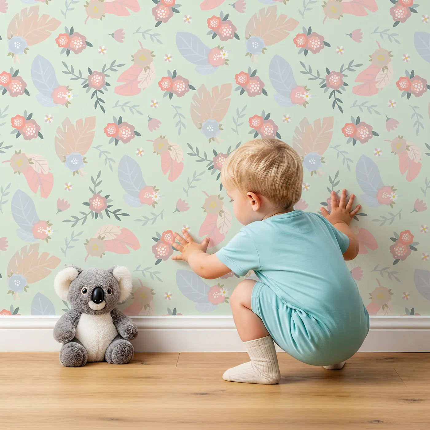 Lovely child standing in front of Whimsy Tots Floating Botanical Whispers Wallpaper in Garden Mint Green with flower, leaf, feather, peony in design.