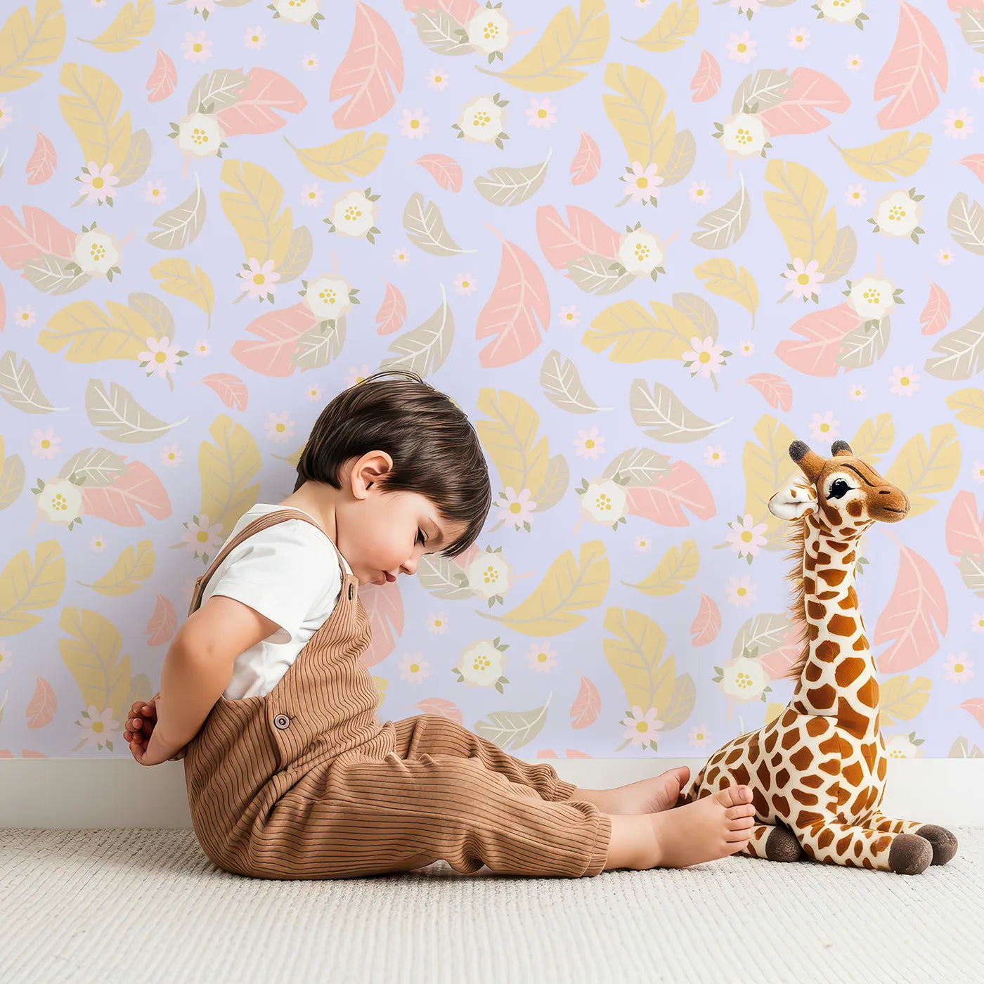 Lovely child standing in front of Whimsy Tots Floral Feather Drift Wallpaper in Lavender Mist with feather, flower, blossom, leaf in design.