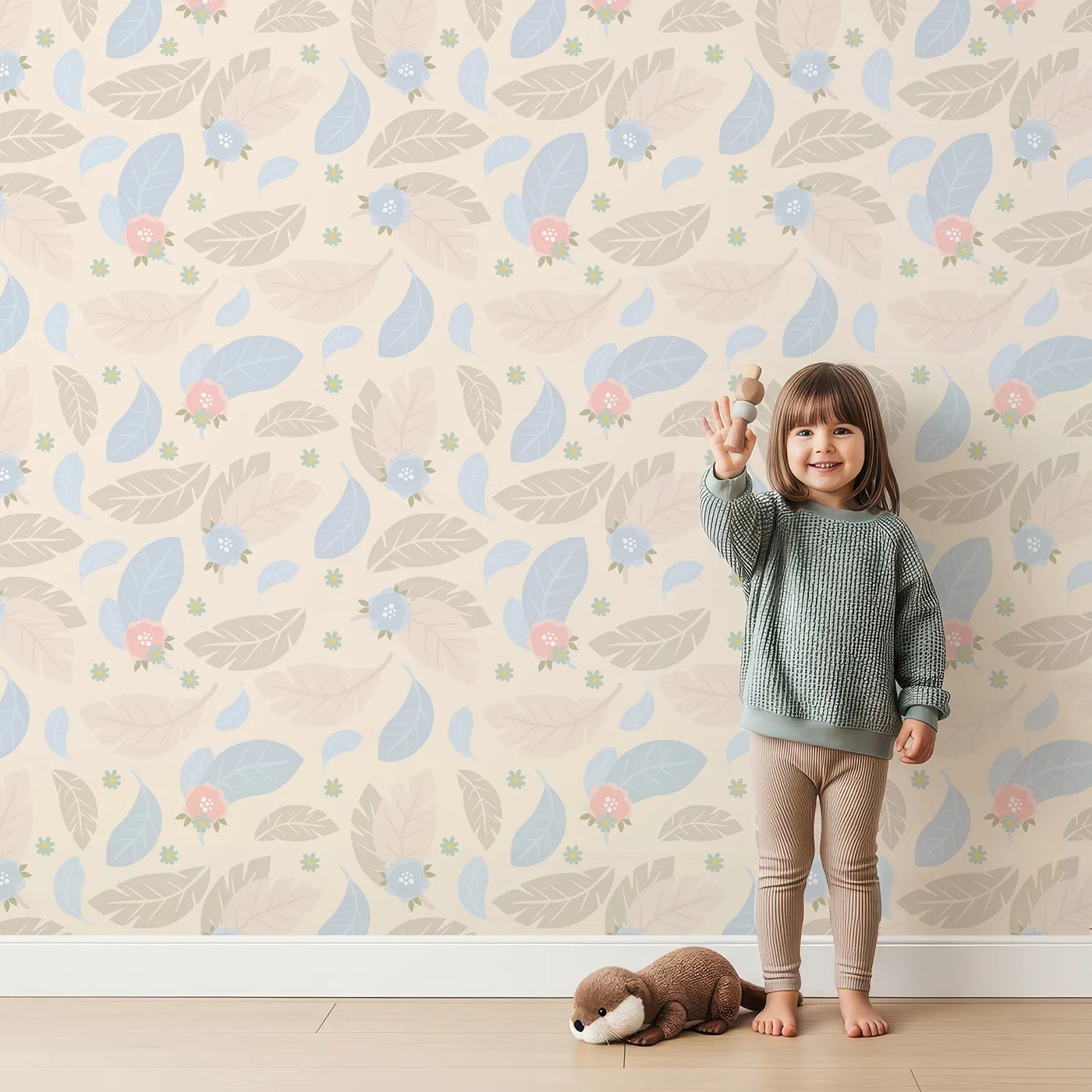 Lovely child standing in front of Whimsy Tots Whispering Petal Leaves Wallpaper in Buttercream with leaf, flower, petal in design.