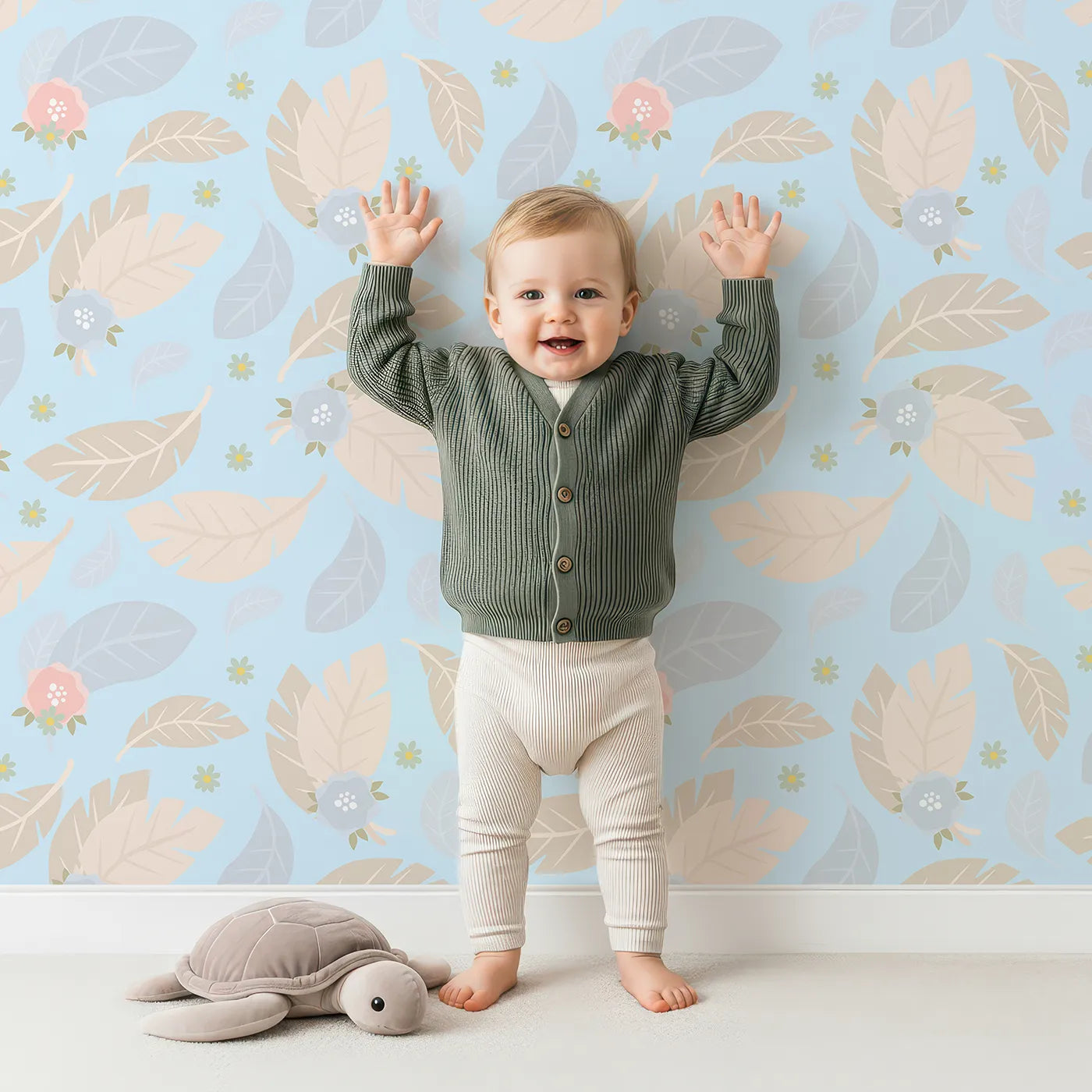 Lovely child standing in front of Whimsy Tots Whispering Petal Leaves Wallpaper in Sky Blue with leaf, flower, petal in design.