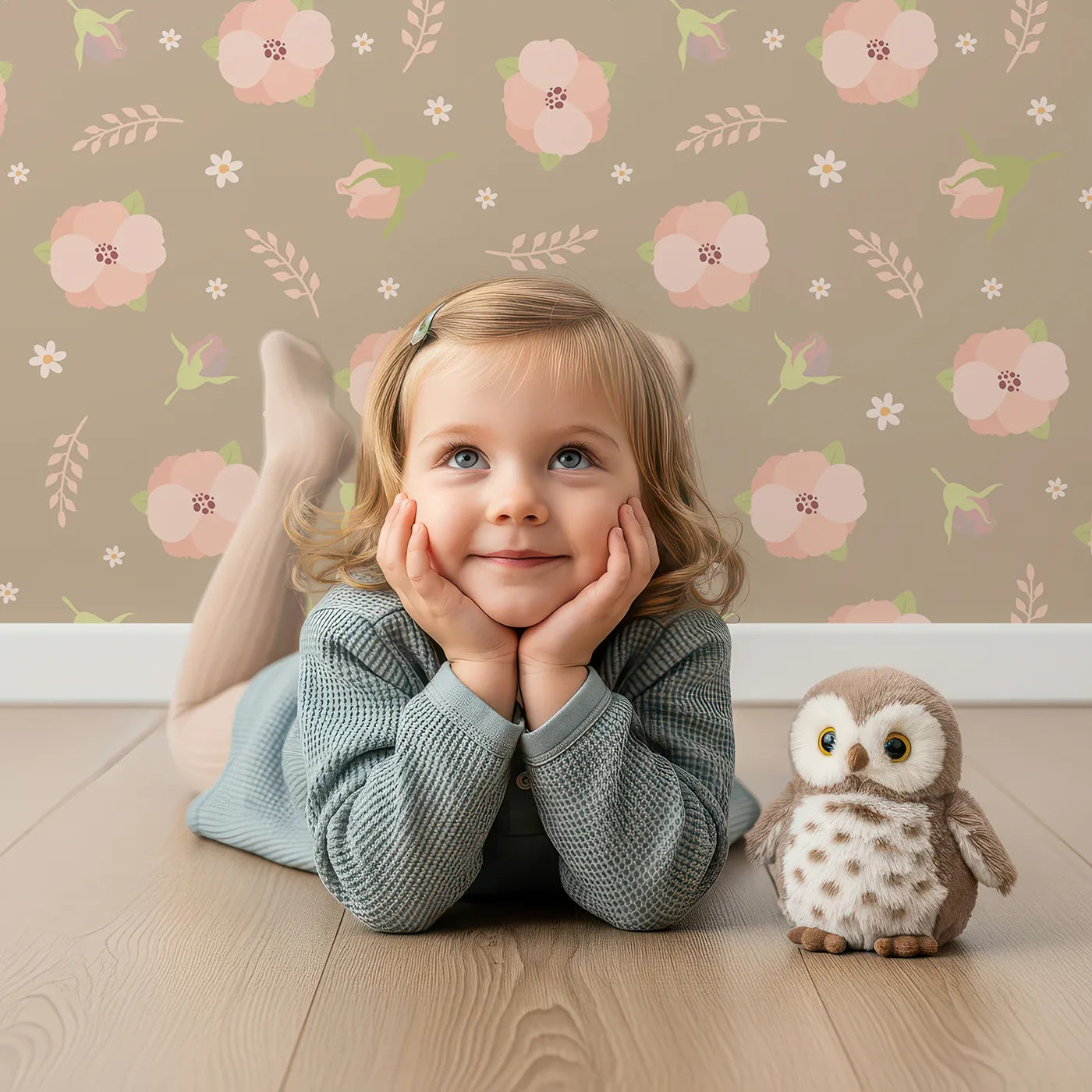 Lovely child standing in front of Whimsy Tots Blush Meadow Bloom Wallpaper in Soft Taupe Beige with flower, daisy, leaf, petal in design.
