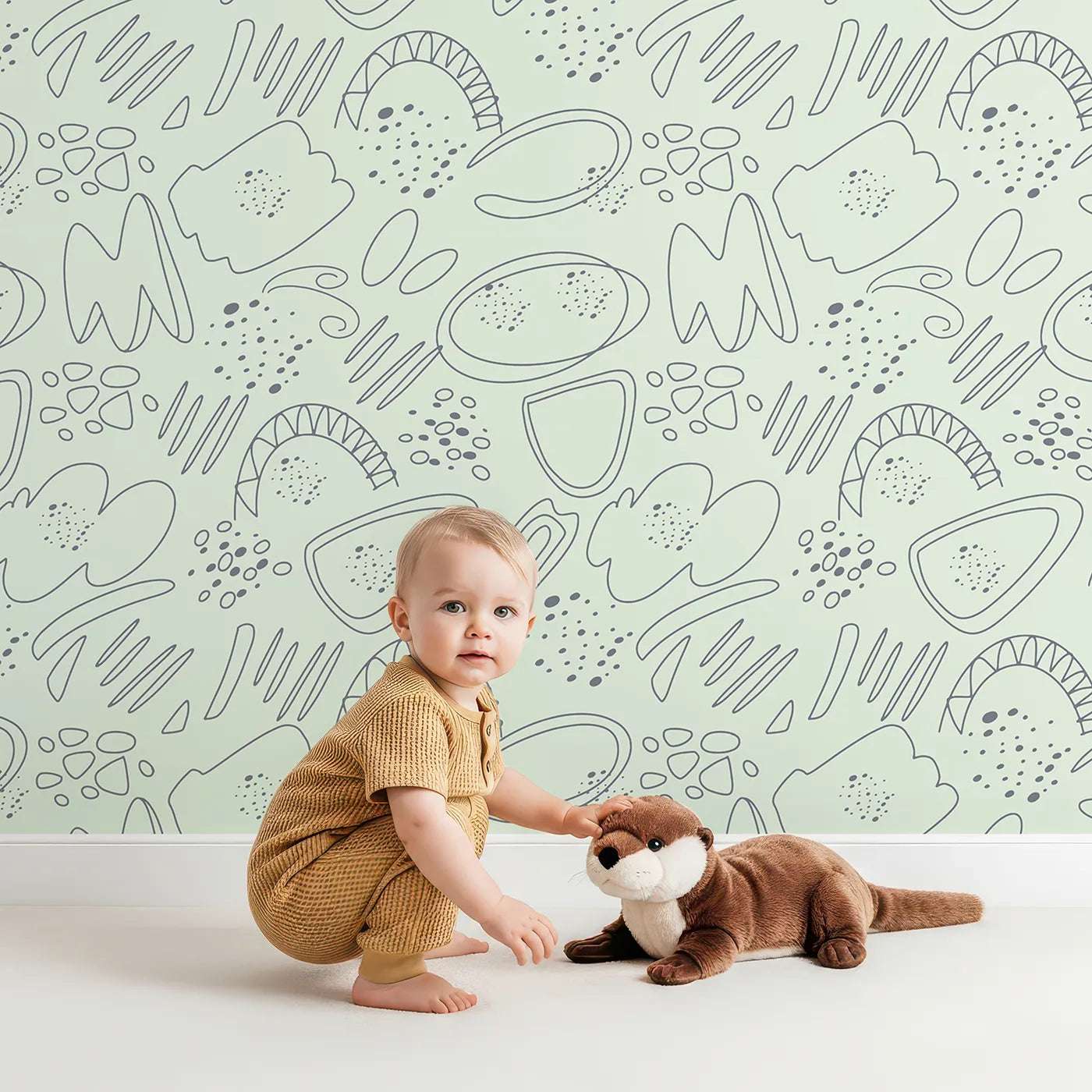Lovely child standing in front of Whimsy Tots Doodle Meadow Shapes Wallpaper in Mint Green with doodle, shape, petal, scribble, arch in design.