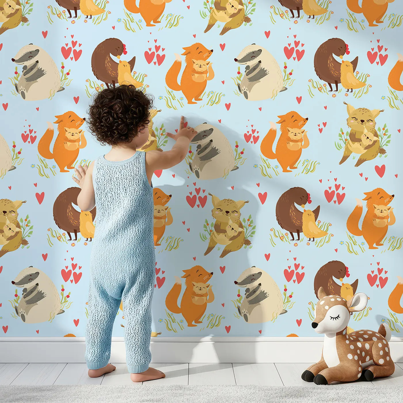 Lovely child standing in front of Whimsy Tots Cuddle Buddies Parade Wallpaper in Blue with fox, bird, badger, cat, heart, flower in design.