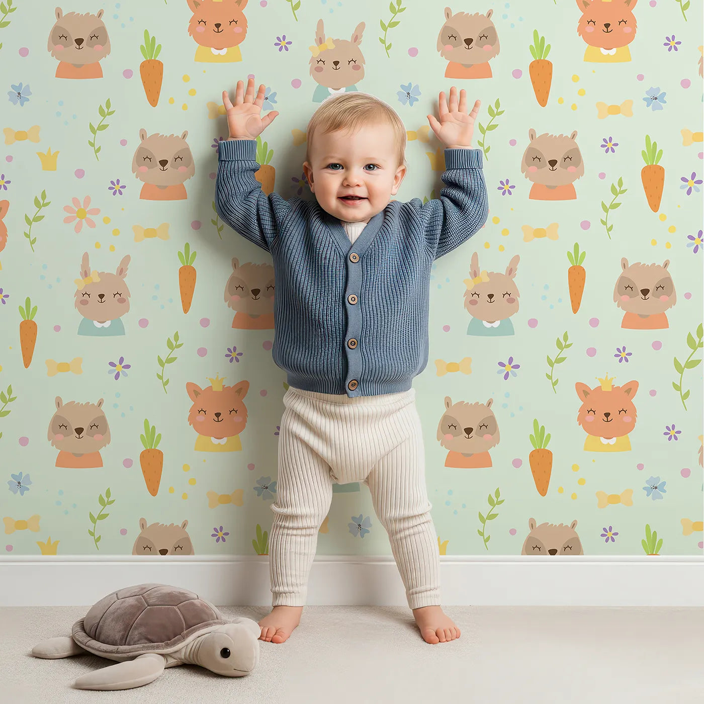 Lovely child standing in front of Whimsy Tots Meadow Crown Friends Wallpaper in Mint Green with fox, rabbit, bear, flower, carrot, crown, bow in design.