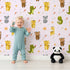 Lovely child standing in front of Whimsy Tots Wild Heart Animal Parade Wallpaper in Soft Lilac Lavender with giraffe, koala, leopard, monkey, tiger, crocodile, heart, arrow, star in design.