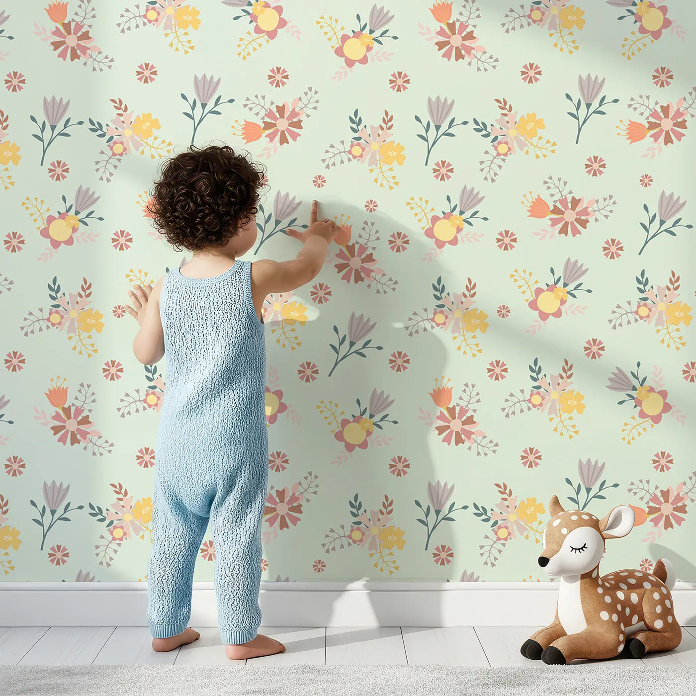 Lovely child standing in front of Whimsy Tots Sunbeam Wildflower Parade Wallpaper in Mint Green with flower, wildflower, leaf, bouquet in design.