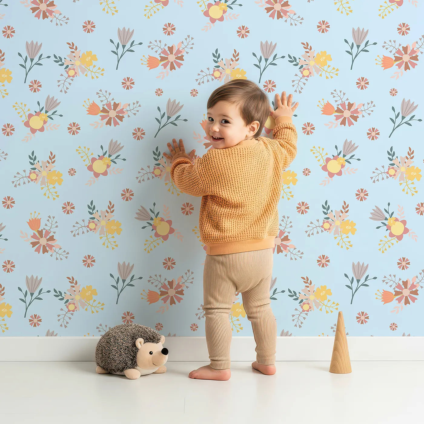Lovely child standing in front of Whimsy Tots Sunbeam Wildflower Parade Wallpaper in Blue with flower, wildflower, leaf, bouquet in design.