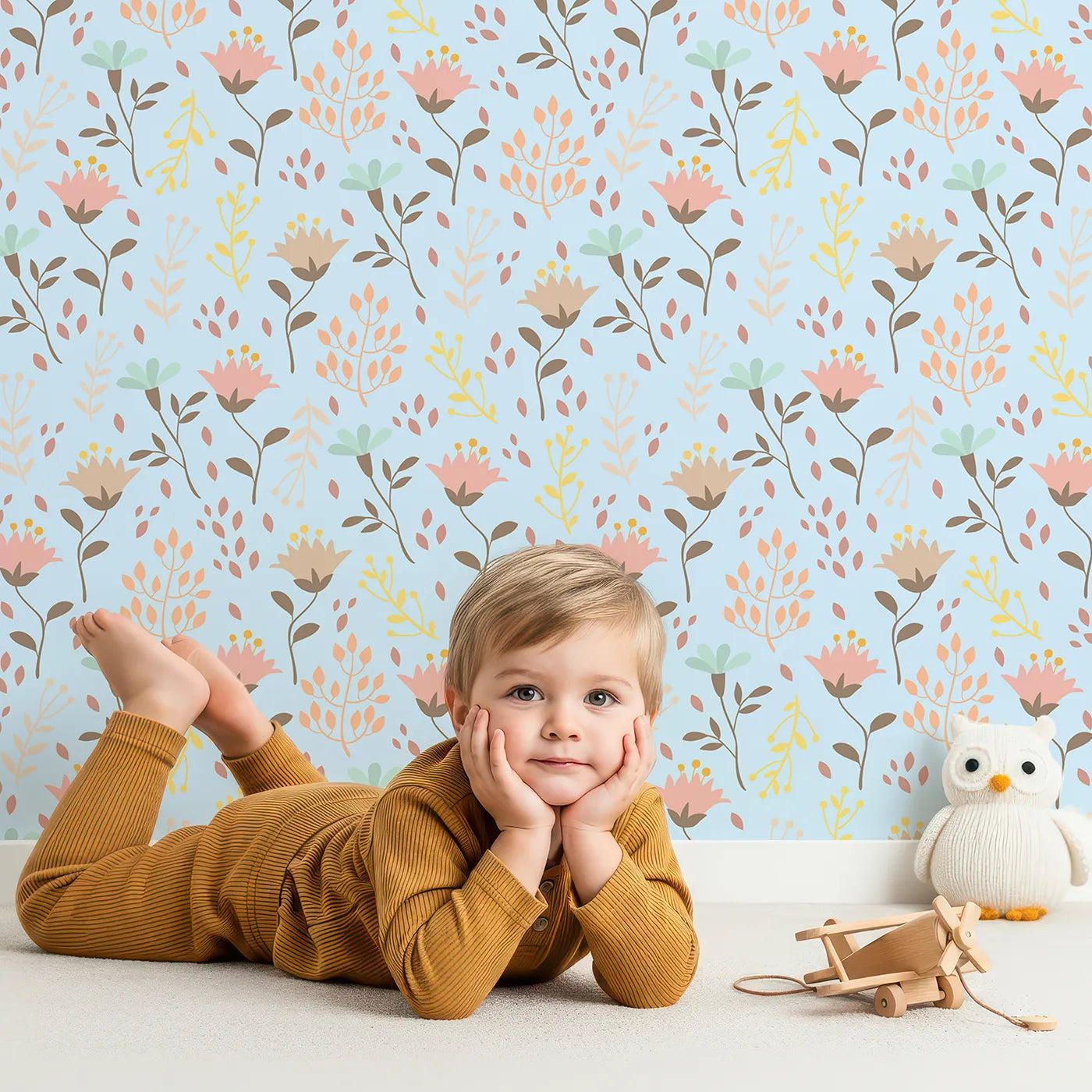 Lovely child standing in front of Whimsy Tots Blooming Meadow Stems Wallpaper in Blue with flower, leaf, wildflower, stem in design.