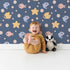 Lovely child standing in front of Whimsy Tots Bubblefish Coral Drift Wallpaper in Midnight Blue with fish, coral, bubble, starfish in design.