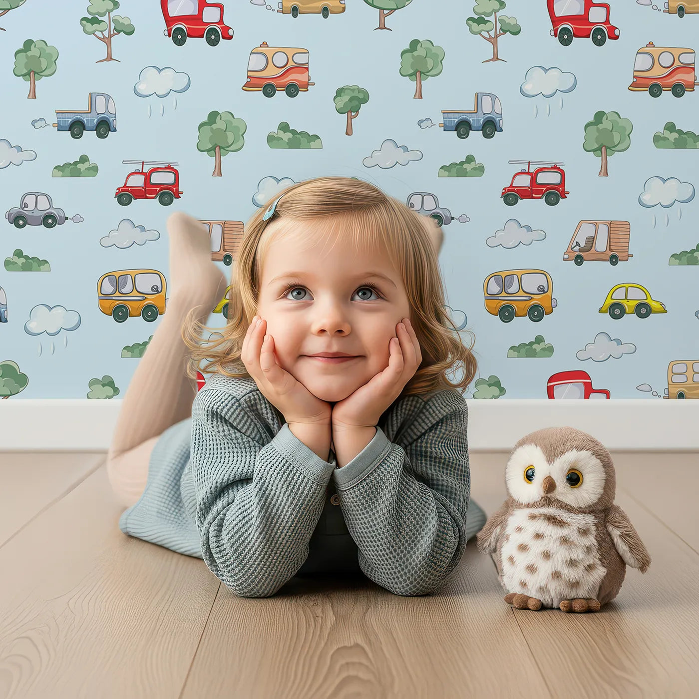 Lovely child standing in front of Whimsy Tots Bumper Buddies Forest Drive Wallpaper in Sky Blue with car, tree, cloud, raindrop, bus in design.