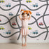 Lovely child standing in front of Whimsy Tots Bumper Buddies Road Maze Wallpaper in Soft Pink with car, road, truck, taxi in design.