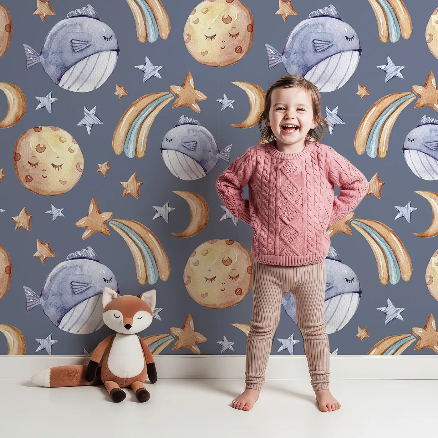 Lovely child standing in front of Whimsy Tots Starry Whale Drift Wallpaper in Indigo with whale, moon, star, comet in design.
