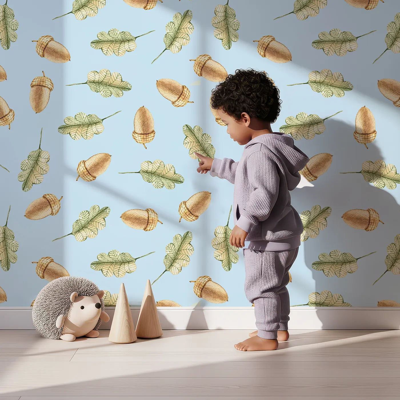 Lovely child standing in front of Whimsy Tots Acorn Meadow Whimsy Wallpaper in Blue with acorn, oak leaf, leaf in design.