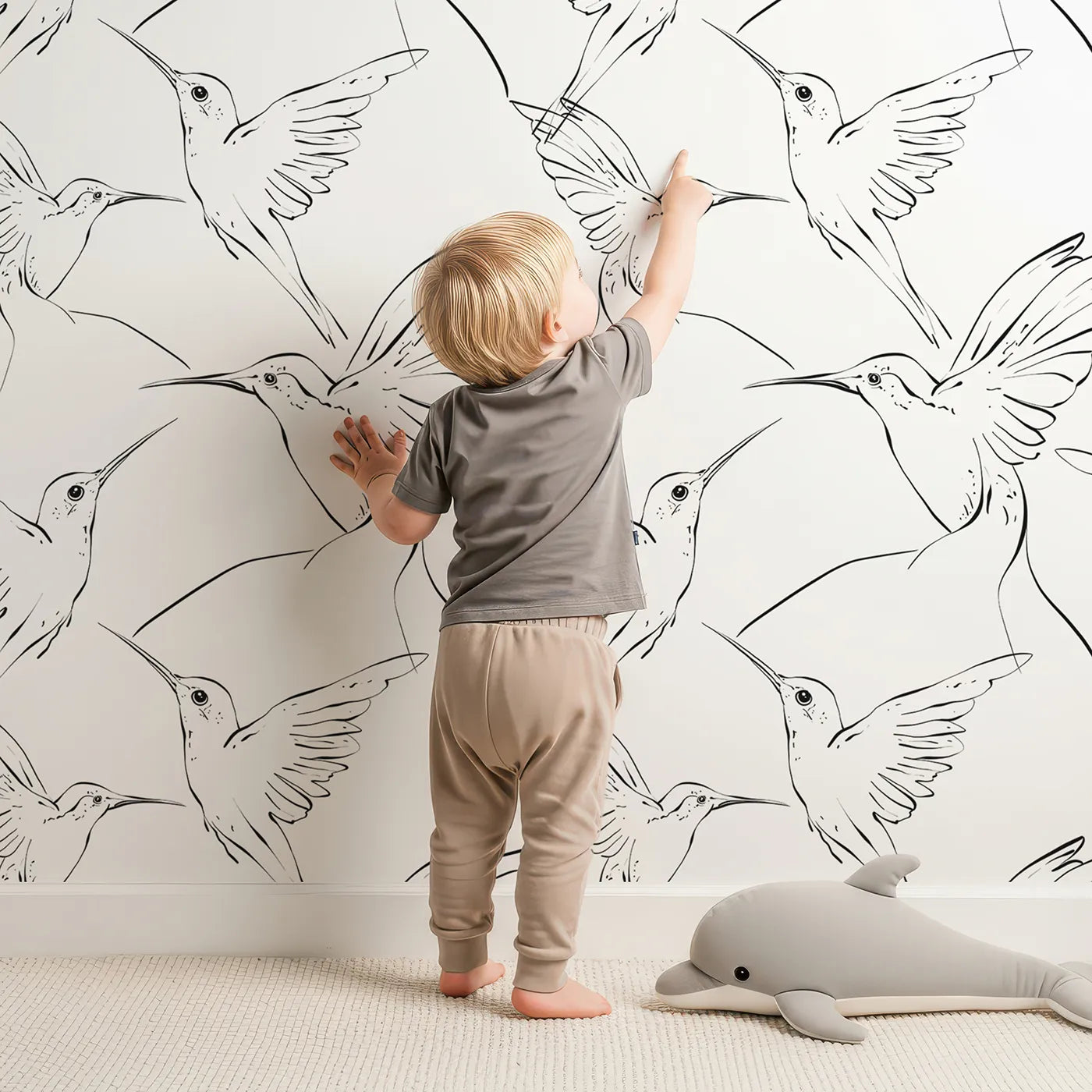 Lovely child standing in front of Whimsy Tots Inkline Hummingbird Wallpaper with hummingbird, bird, wing, sketch in design.
