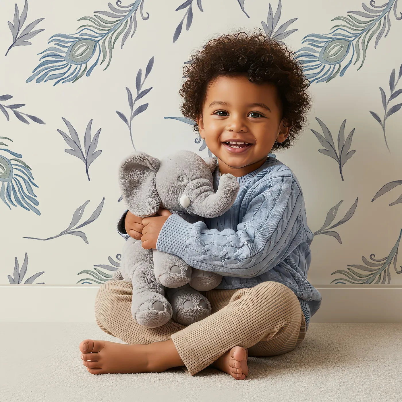 Lovely child standing in front of Whimsy Tots Feather and Foliage Dance Wallpaper in Mist Blue with feather, leaf, peacock in design.