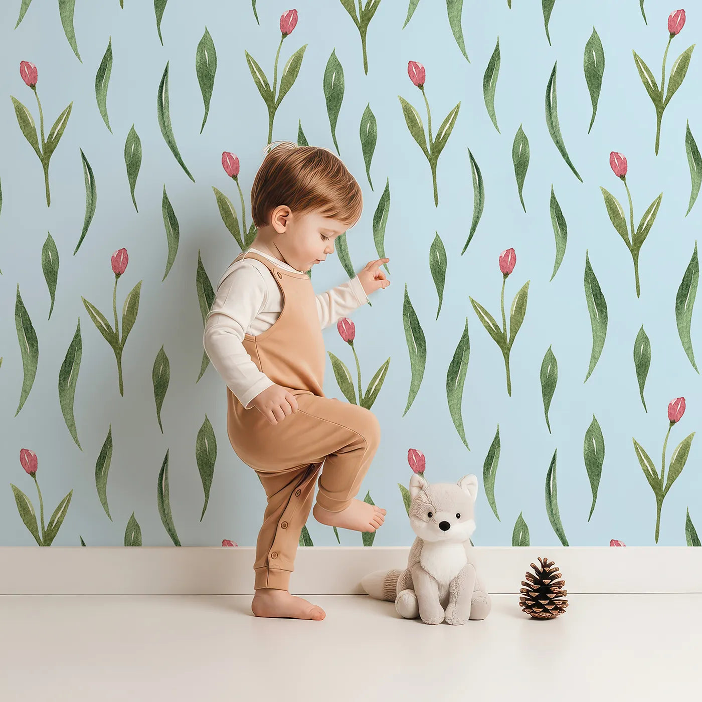 Lovely child standing in front of Whimsy Tots Tulip Meadow Dots Wallpaper in Sky Blue with flower, leaf, tulip in design.