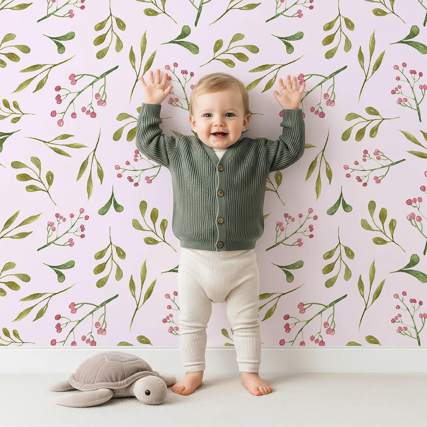 Lovely child standing in front of Whimsy Tots Botanical Berry Sprigs Wallpaper in Blush Pink with berry, leaf, sprig in design.