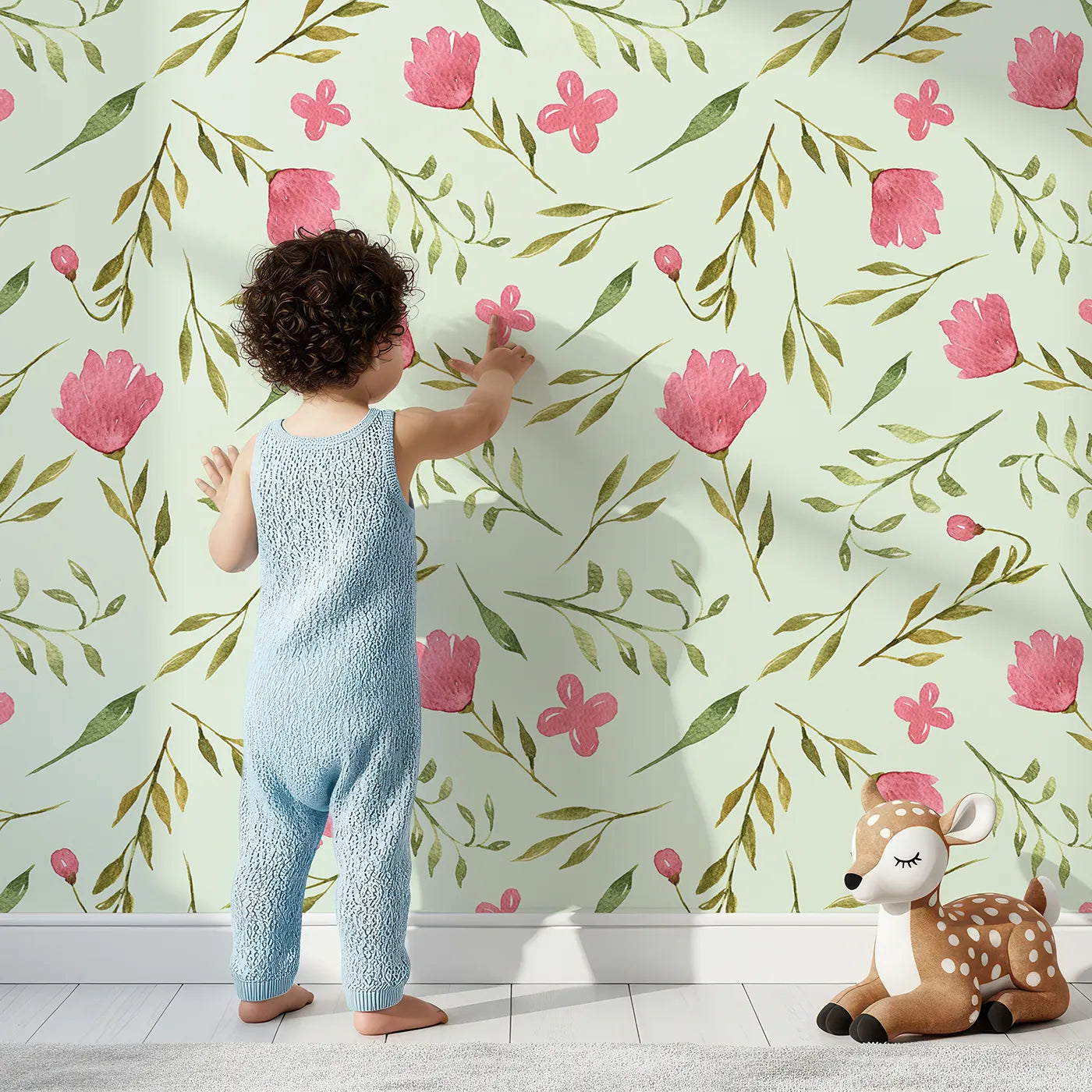 Lovely child standing in front of Whimsy Tots Blushing Petal Tangle Wallpaper in Mint Green with flower, leaf, petal, vine in design.