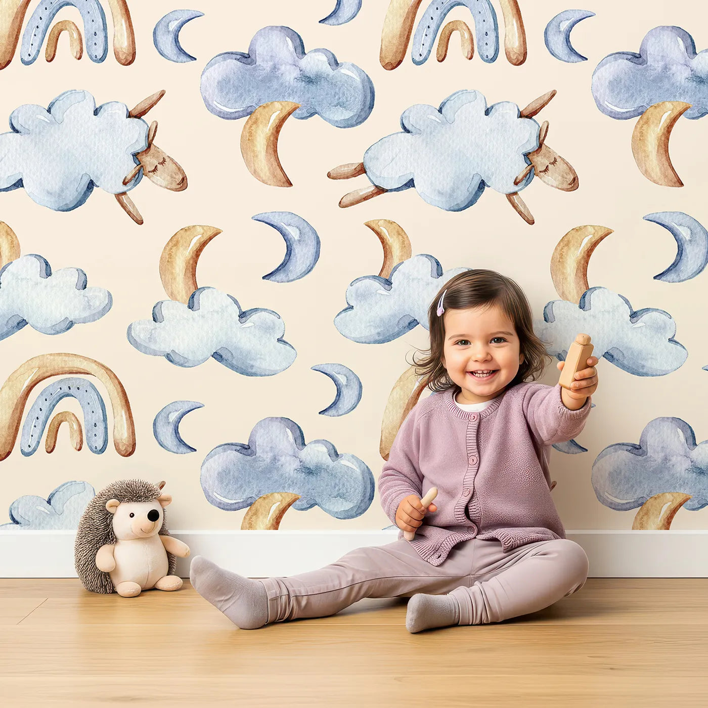 Lovely child standing in front of Whimsy Tots Sleepy Skies Wallpaper in Cream with cloud, moon, rainbow, sheep in design.