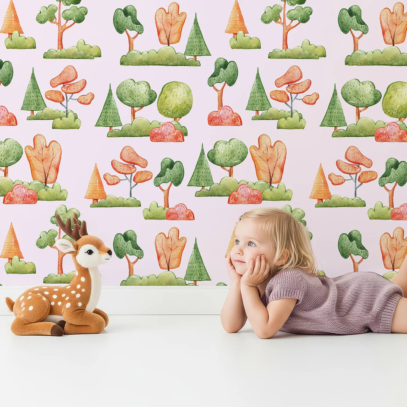Lovely child standing in front of Whimsy Tots Autumn Meadow Grove Wallpaper in Pink with tree, bush in design.