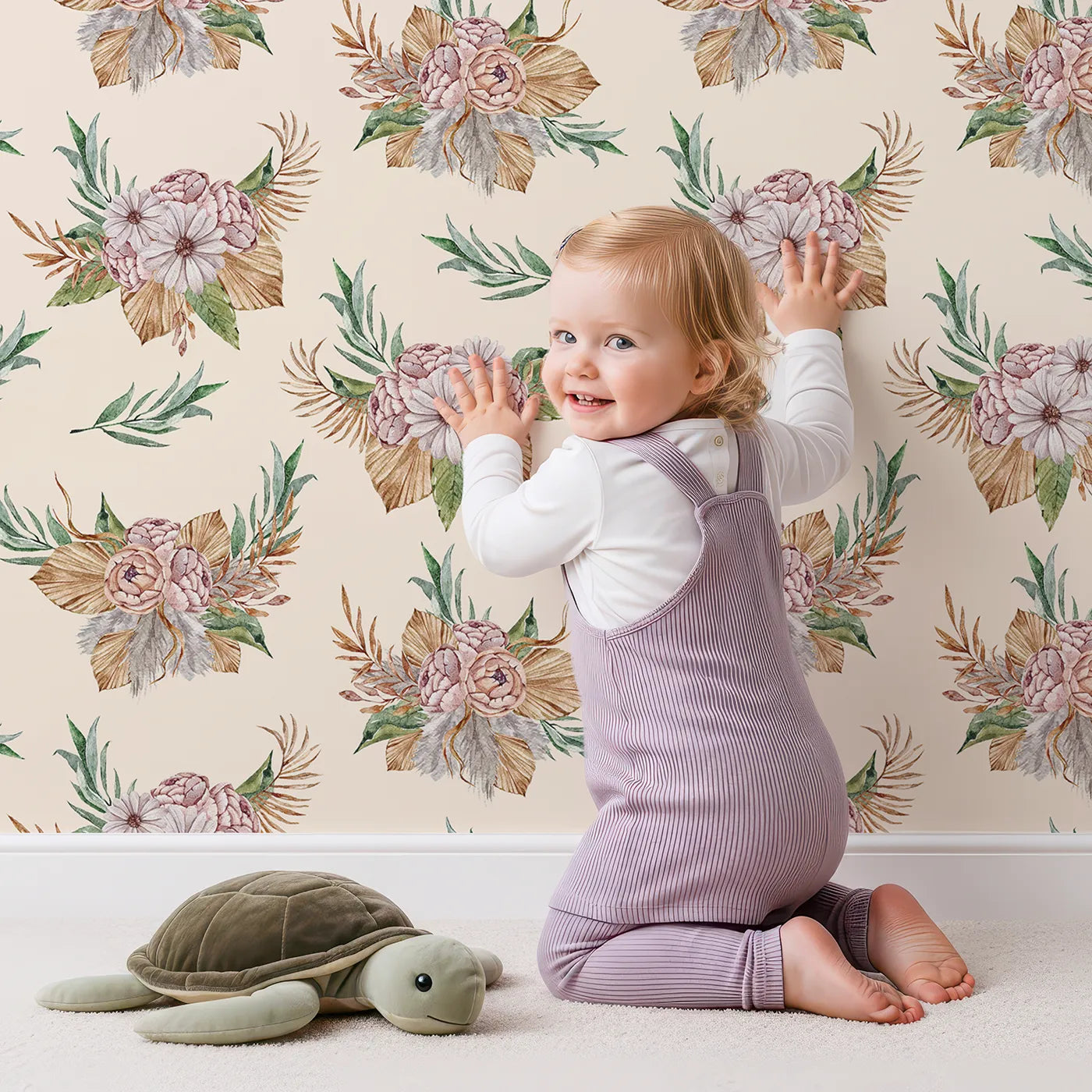 Lovely child standing in front of Whimsy Tots Rustic Blush Bouquet Wallpaper in Cream with flower, palm, leaf in design.