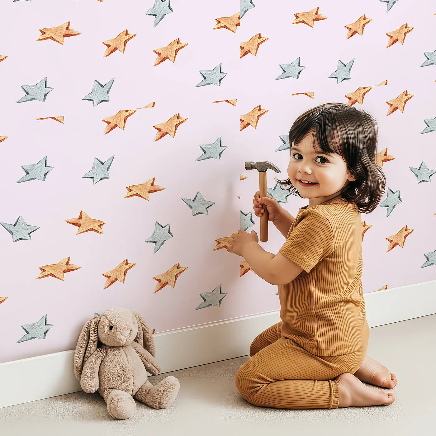 Lovely child standing in front of Whimsy Tots Wooden Star Sprinkle Wallpaper in Pink with star in design.