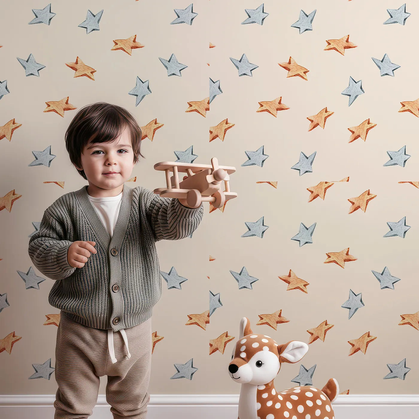 Lovely child standing in front of Whimsy Tots Wooden Star Sprinkle Wallpaper in Beige with star in design.