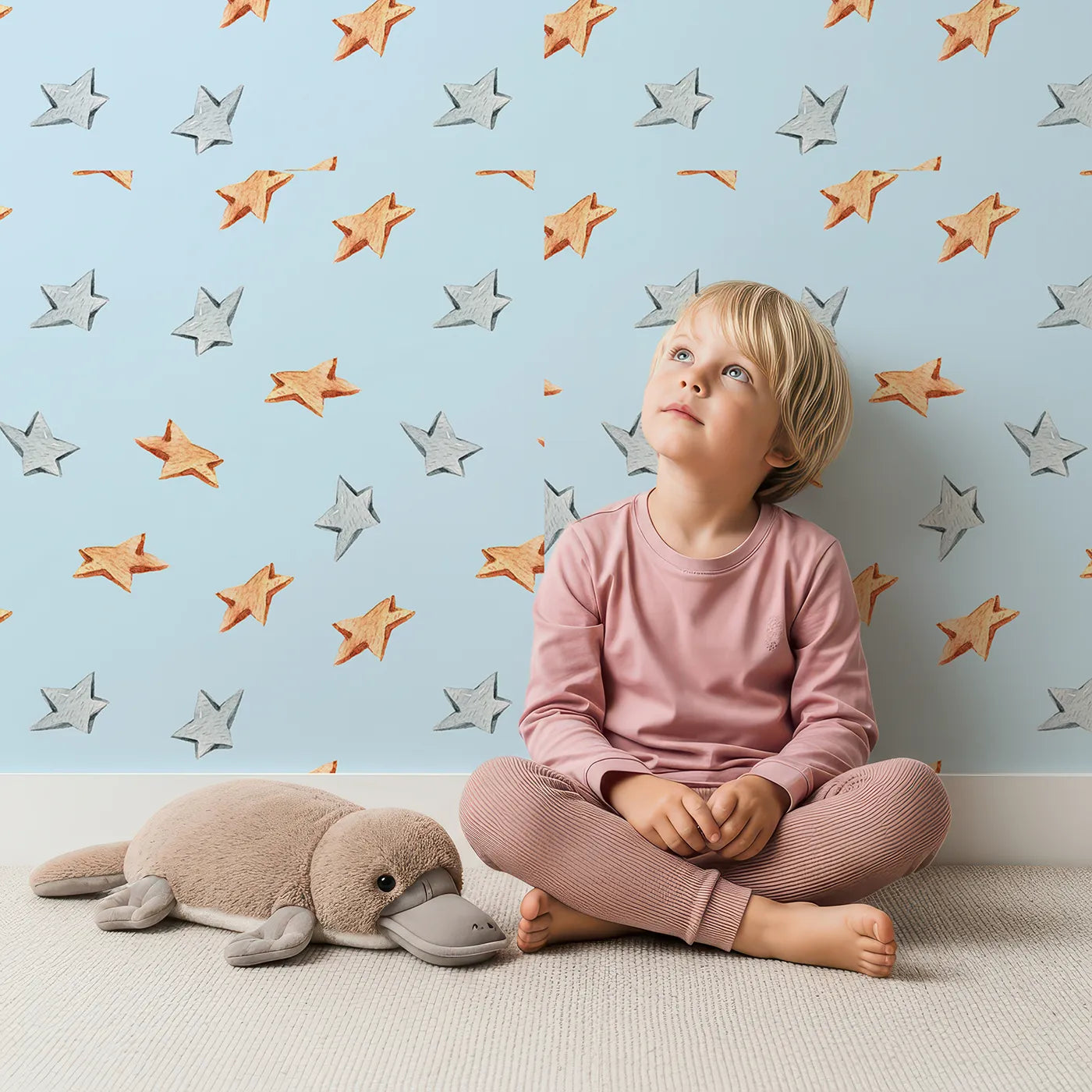 Lovely child standing in front of Whimsy Tots Wooden Star Sprinkle Wallpaper in Blue with star in design.