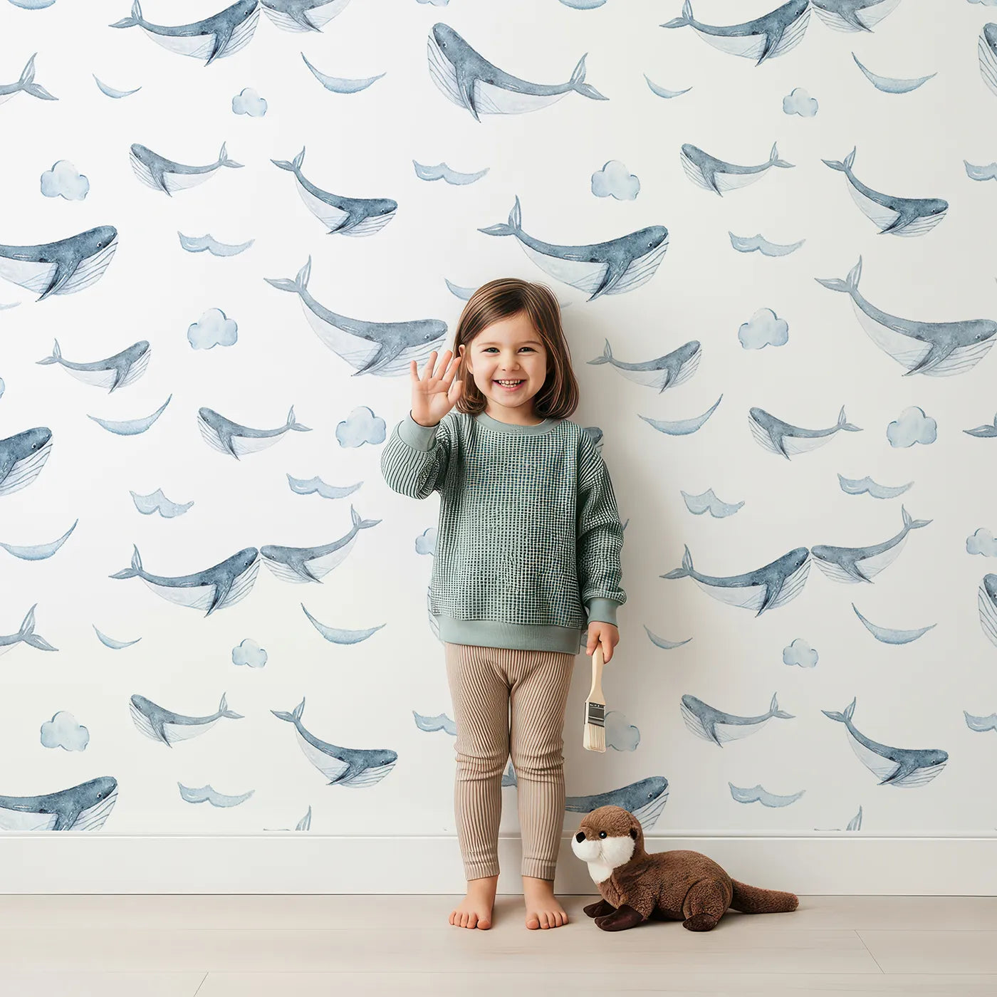 Lovely child standing in front of Whimsy Tots Whale Cloud Voyage Wallpaper in White with whale, cloud, splash in design.