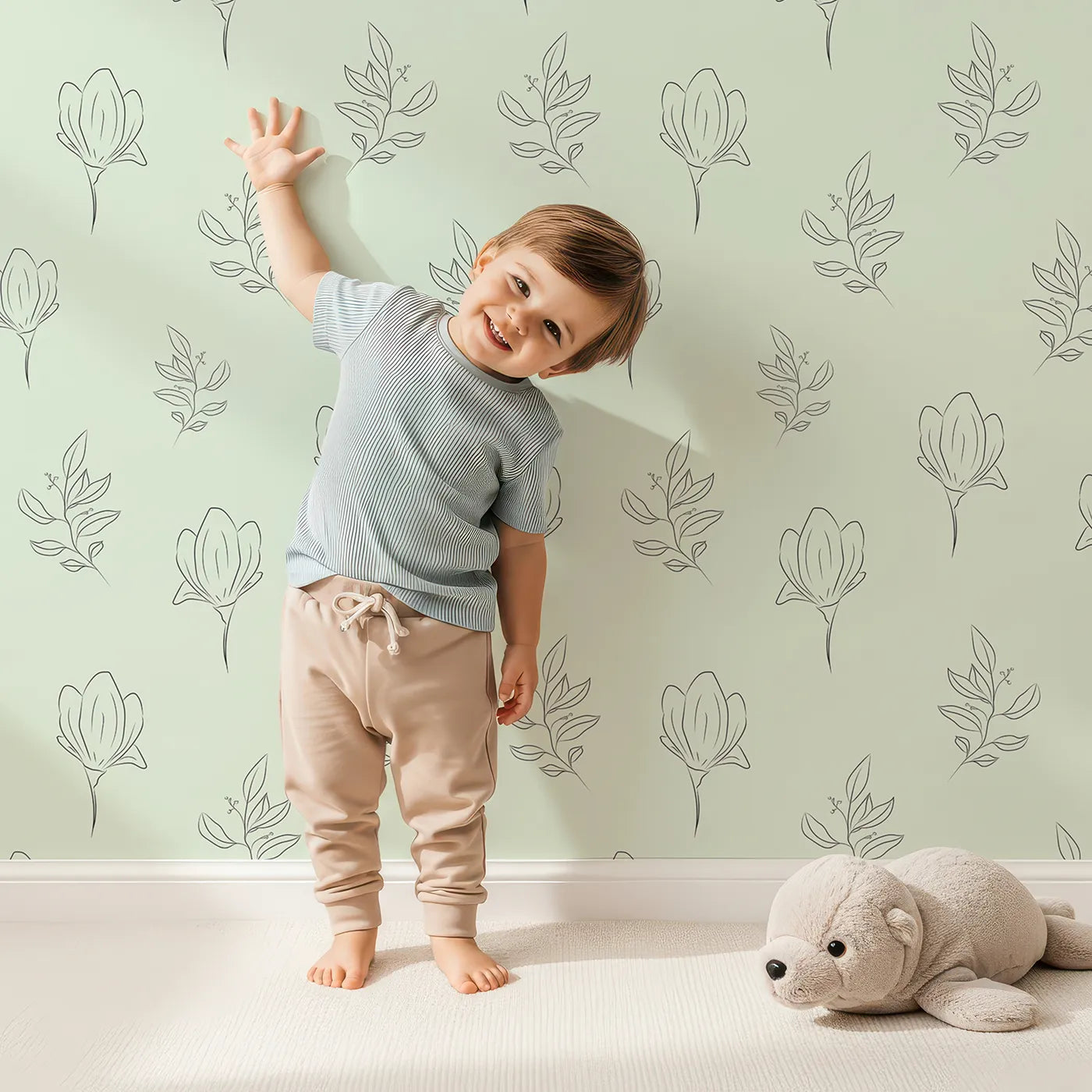 Lovely child standing in front of Whimsy Tots Floral Whisper Line Art Wallpaper in Mint Green with flower, leaf, blossom, lineart in design.