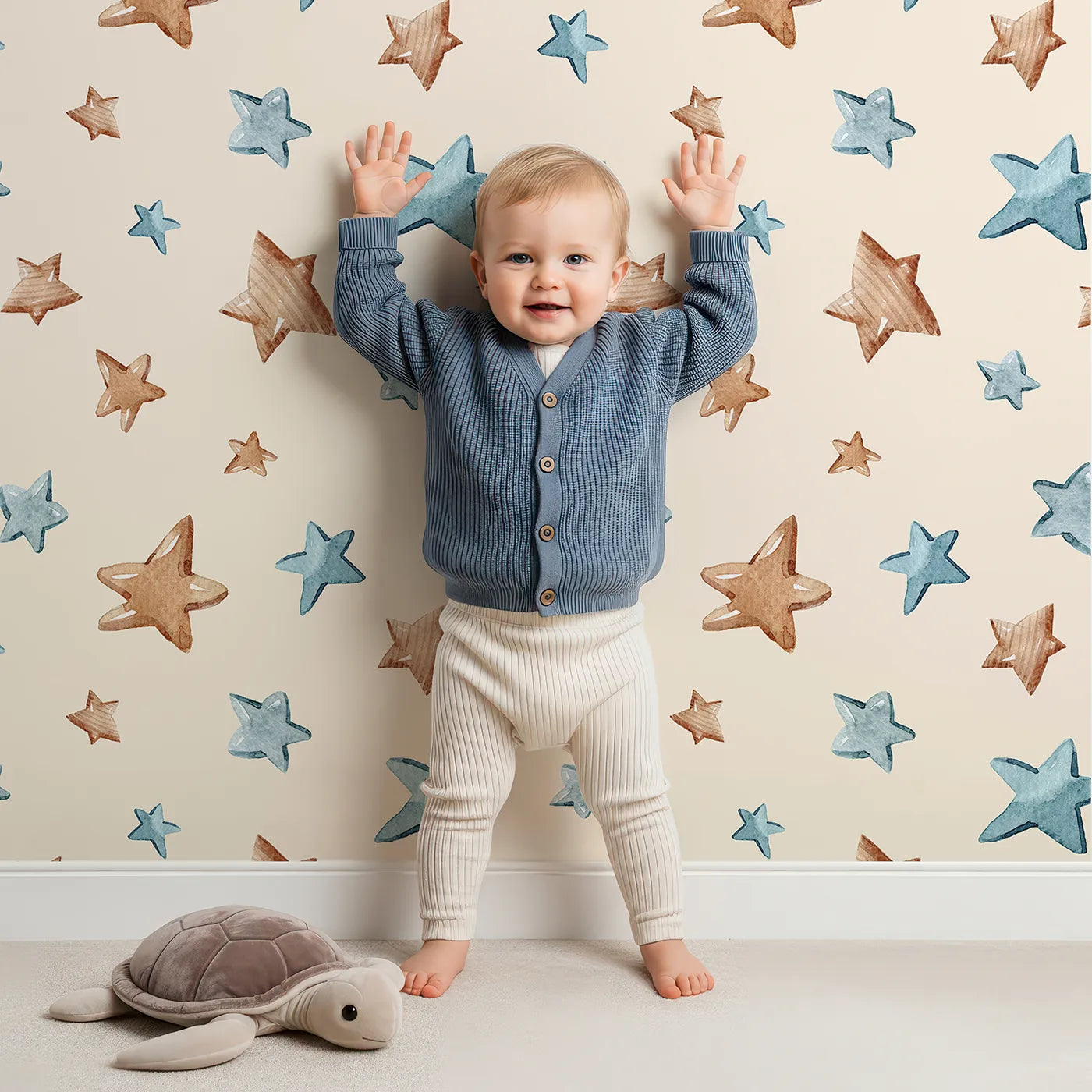 Lovely child standing in front of Whimsy Tots Starry Drift Wallpaper in Cream with star, watercolor, sky, night in design.