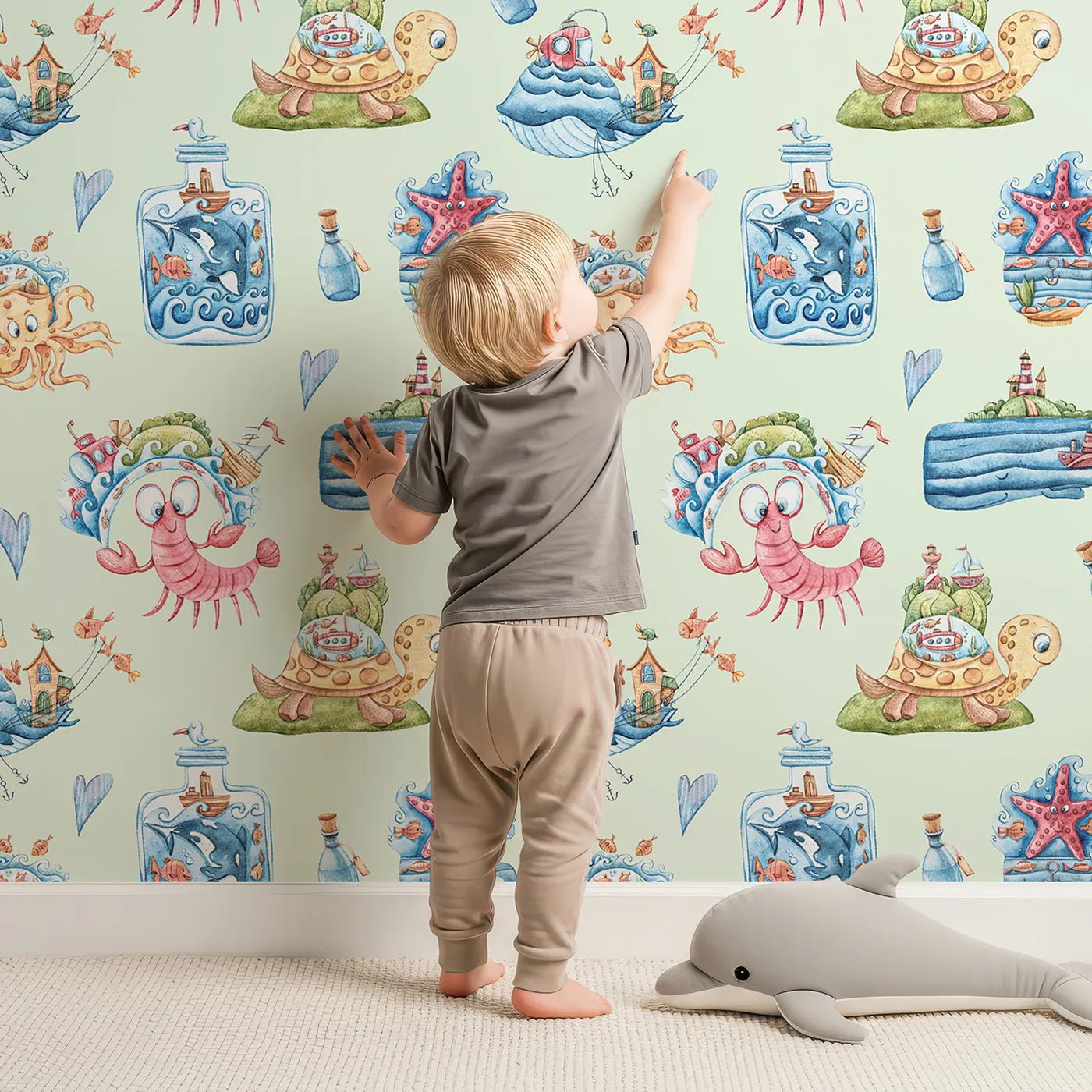 Lovely child standing in front of Whimsy Tots Seaside Story Friends in Mint Green with octopus, turtle, whale, dolphin, fish, bottle, island, house, boat in design.