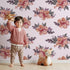 Lovely child standing in front of Whimsy Tots Berry Blush Blooms in Blush Pink with flower, petal, leaf, sprig in design.
