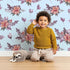 Lovely child standing in front of Whimsy Tots Berry Meadow Whispers in Sky with flower, petal, leaf, sprig in design.