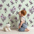 Lovely child standing in front of Whimsy Tots Lilac Sprig Dance in Mint Green with flower, petal, leaf, sprig in design.