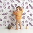 Lovely child standing in front of Whimsy Tots Lavender Leaves Whisper in White with leaf, sprig, branch in design.