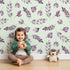 Lovely child standing in front of Whimsy Tots Lavender Leaves Whisper in Mint with leaf, sprig, branch in design.