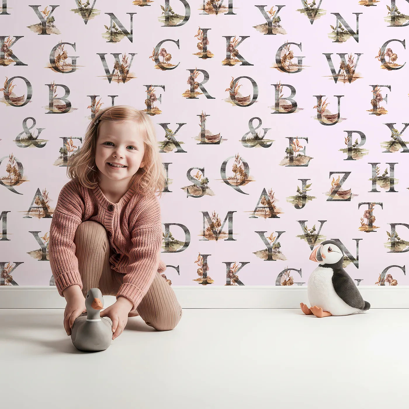 Lovely child standing in front of Whimsy Tots Rustic Alphabet Adventure in Blush Pink with letter, alphabet, tree, boat, plant in design.