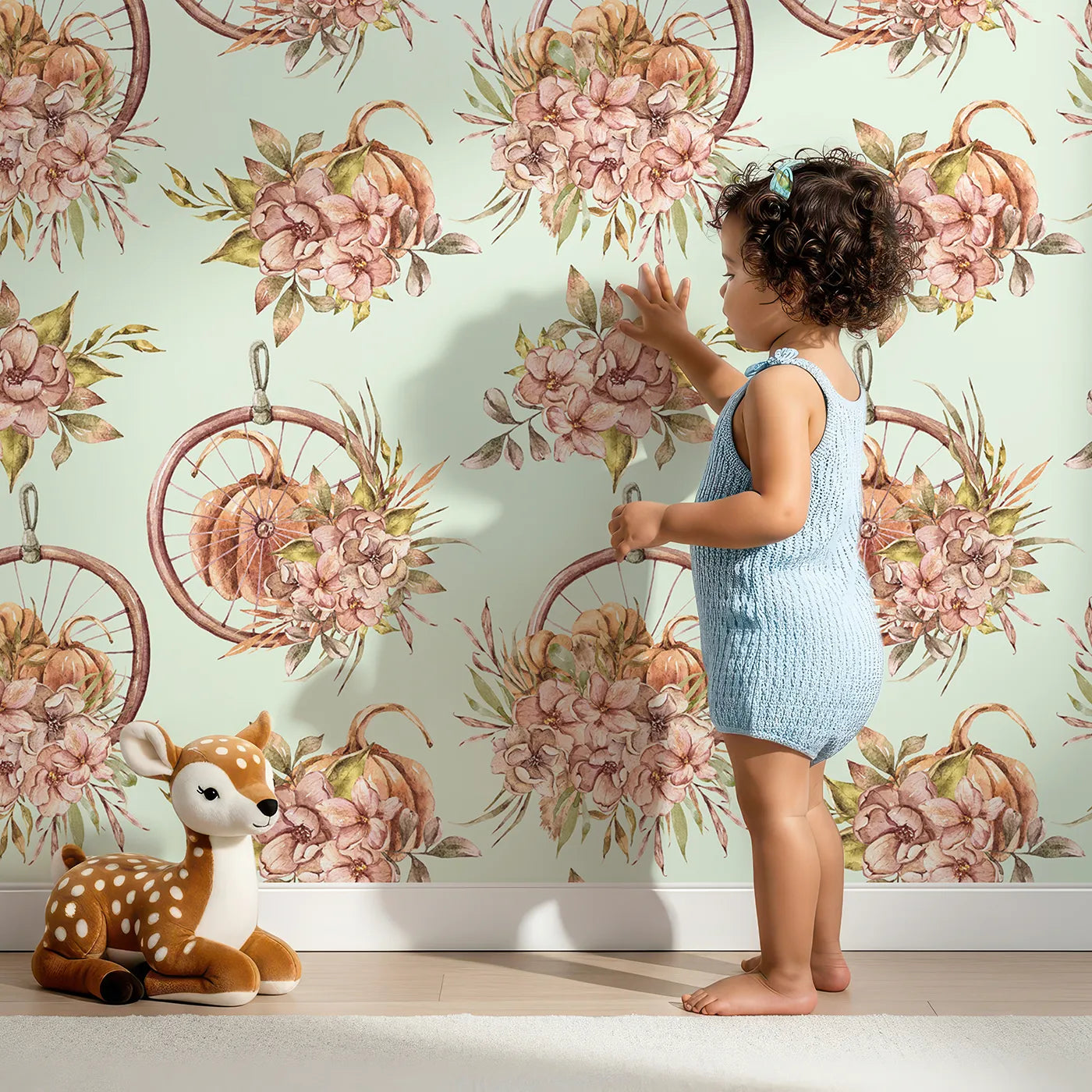 Lovely child standing in front of Whimsy Tots Harvest Bloom Hoop Wallpaper in Sage Green with flower, pumpkin, hoop, leaf in design.