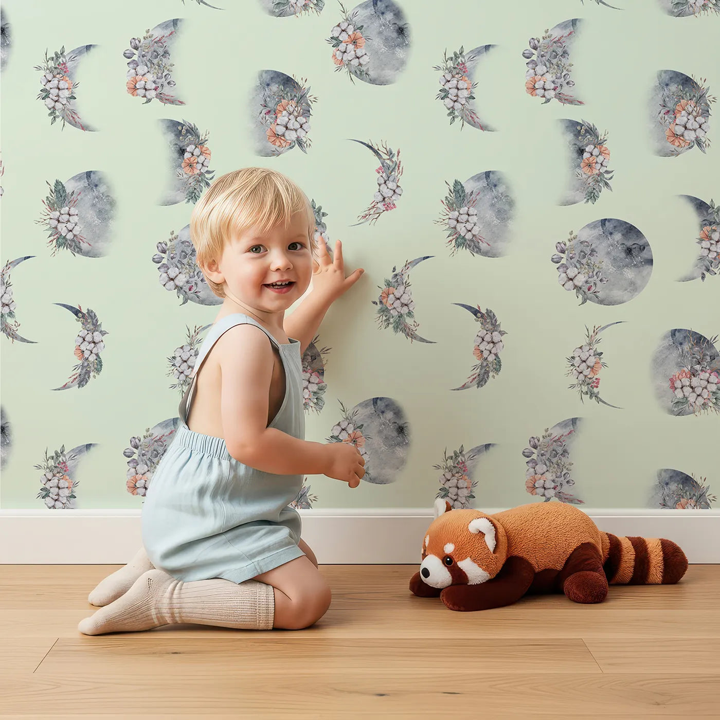 Lovely child standing in front of Whimsy Tots Celestial Winter Blooms Wallpaper in Mint Green with moon, flower, cotton, eucalyptus in design.