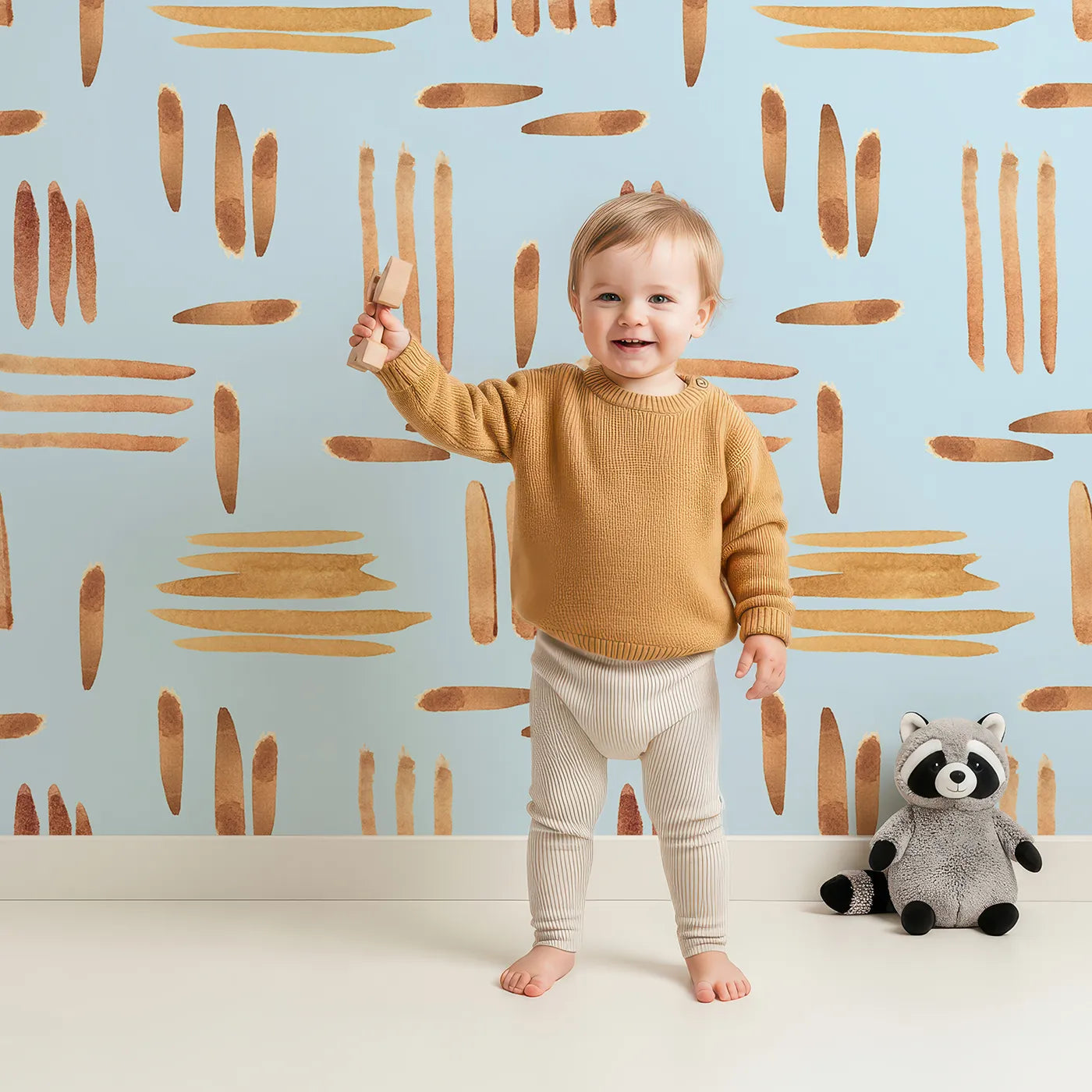 Lovely child standing in front of Whimsy Tots Painted Rhythm Wallpaper in Sky Blue with line, brushstroke in design.