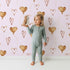 Lovely child standing in front of Whimsy Tots Heartfelt Balloons Wallpaper in Pink with heart, balloon, outline in design.