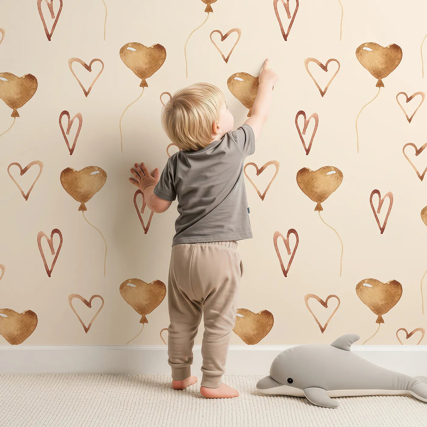 Lovely child standing in front of Whimsy Tots Heartfelt Balloons Wallpaper in Cream with heart, balloon, outline in design.