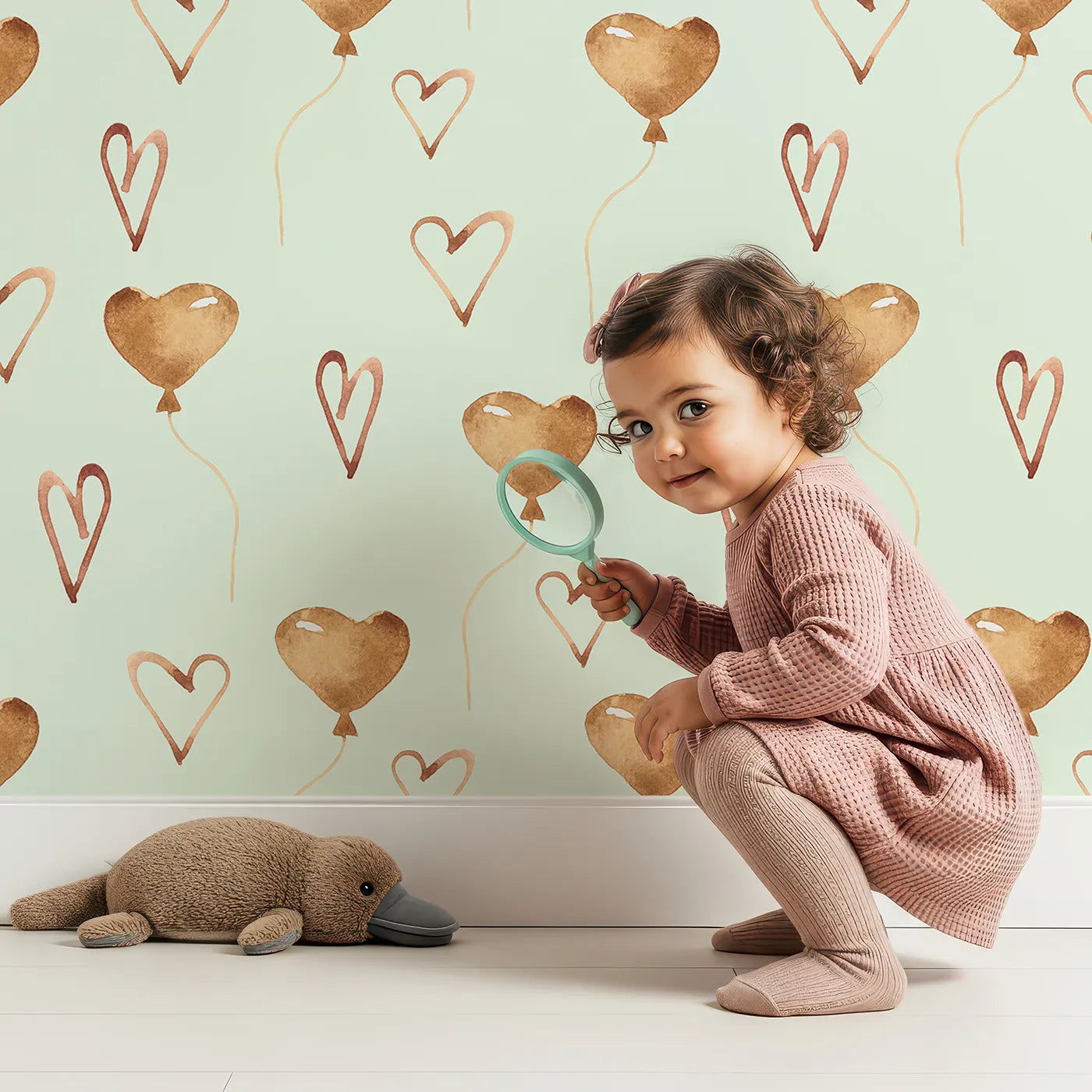 Lovely child standing in front of Whimsy Tots Heartfelt Balloons Wallpaper in Mint Green with heart, balloon, outline in design.