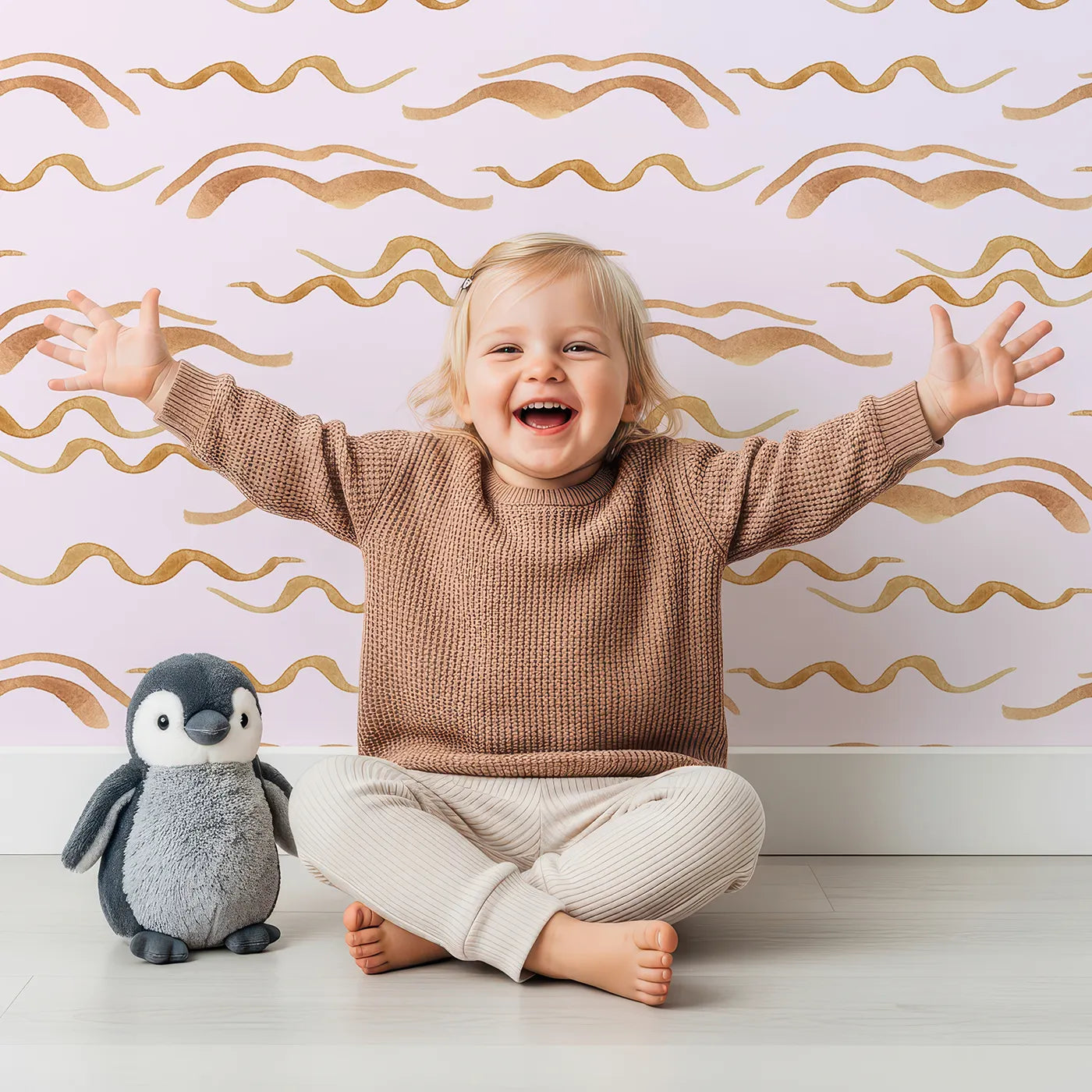 Lovely child standing in front of Whimsy Tots Soft Wave Rhythm Wallpaper in Blush Pink with wave, curve, line, brushstroke, abstract in design.
