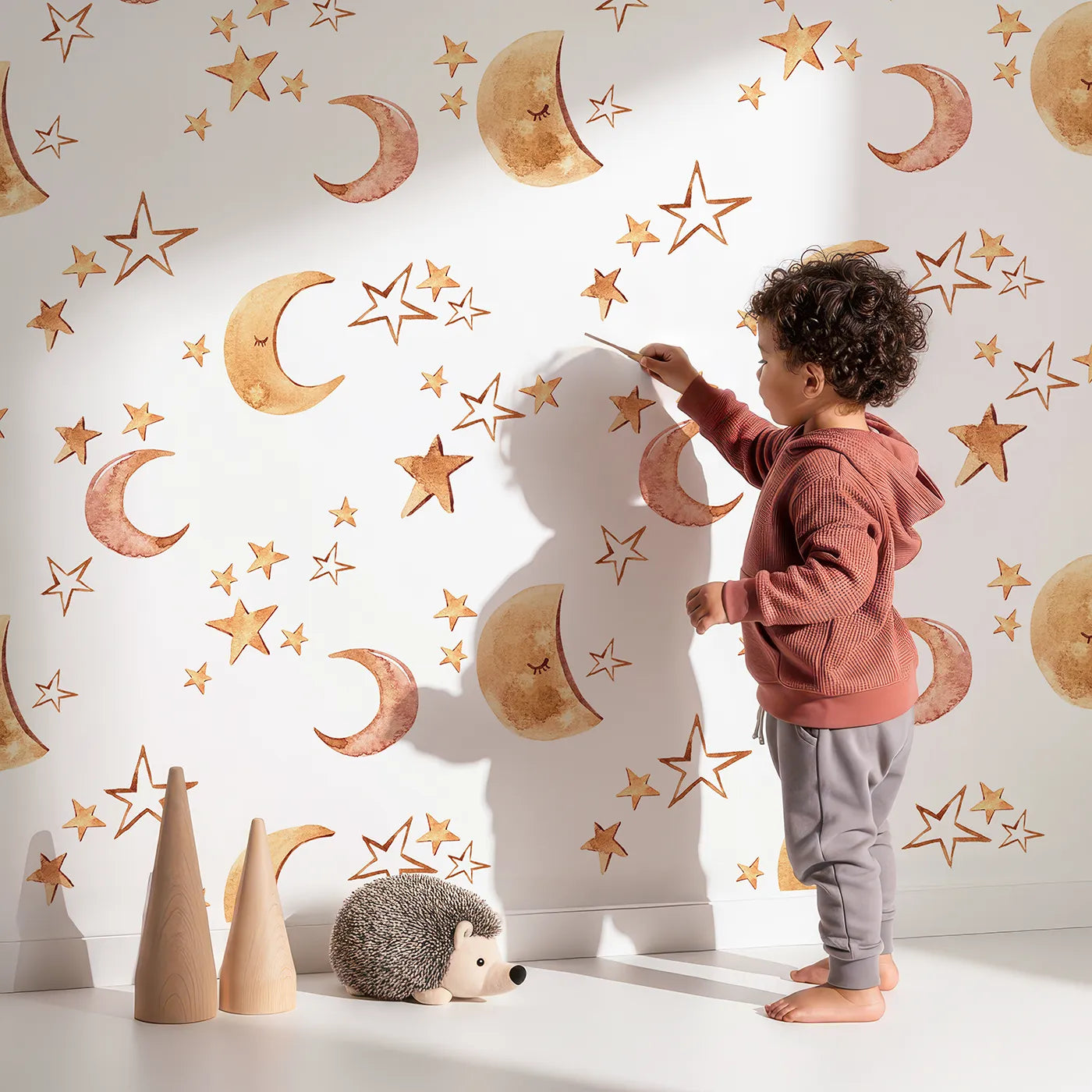 Lovely child standing in front of Whimsy Tots Sleepy Skies Shine Wallpaper in White with moon, star, sky, sleepy face in design.